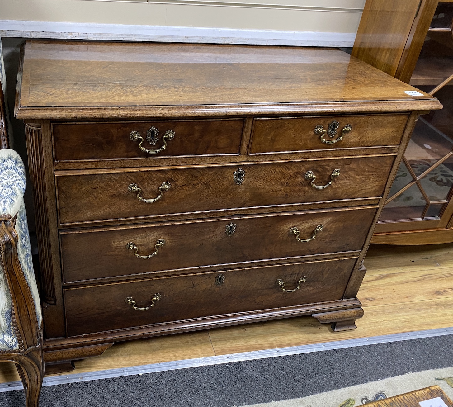 A George III mahogany and crossbanded chest, c.1760, the two short and three long drawers flanked by fluted pilaster corners, on ogee bracket feet, restored, width 105cm, depth 56cm, height 84cm